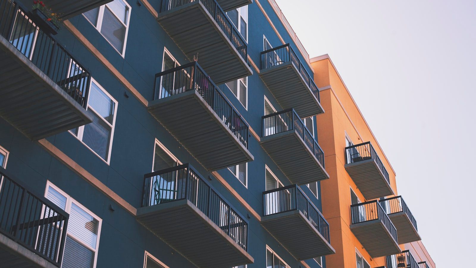 Fachada de prédios residenciais com sacadas em azul e laranja